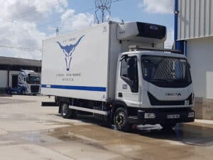 Camion frigorifique Iveco S.T.P./CABRERO blanc, logo taureau. Unité Carrier Supra 850. Texte 'LE SERVICE... NOTRE PRIORITÉ !' et tél. 06.07.81.87.26.